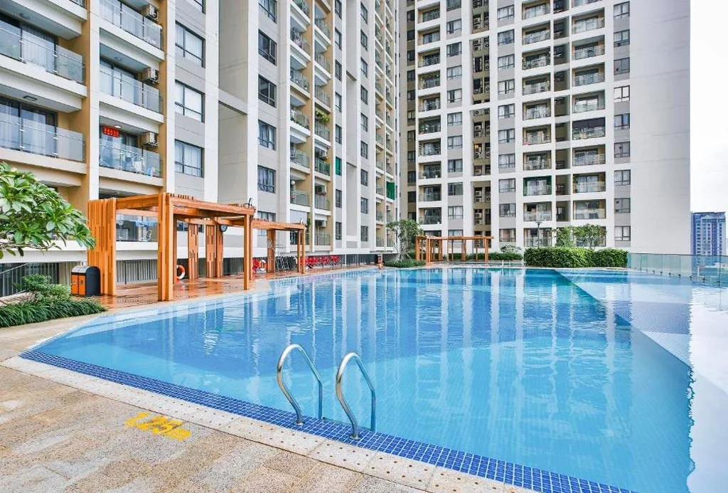 Hồ bơi giữa các khối nhà với ghế nghỉ và lối dạo tại The Gold View