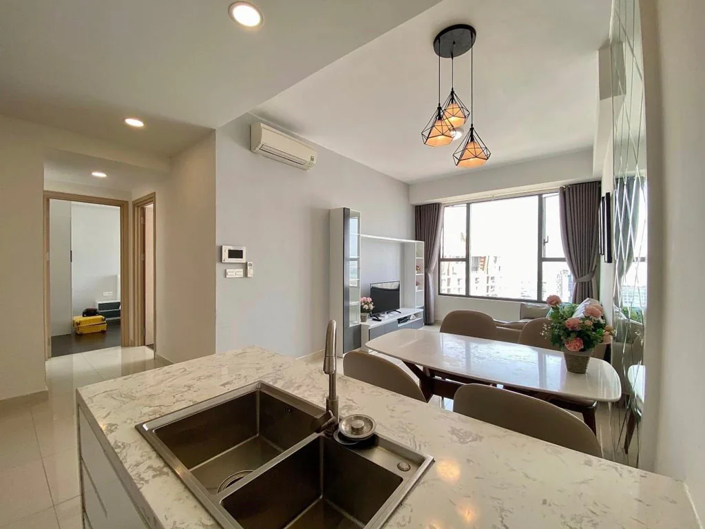 Khu bếp mở kết nối phòng sinh hoạt của một căn hộ RiverGate Residence