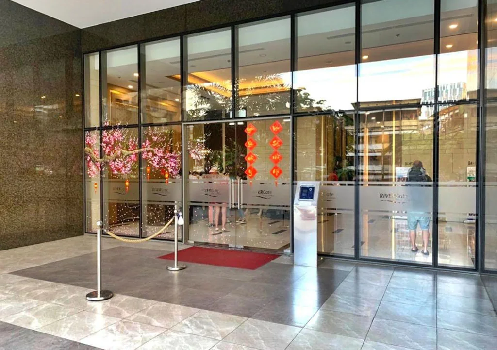 Lối vào sảnh RiverGate Residence với cửa kính và quầy đón tiếp