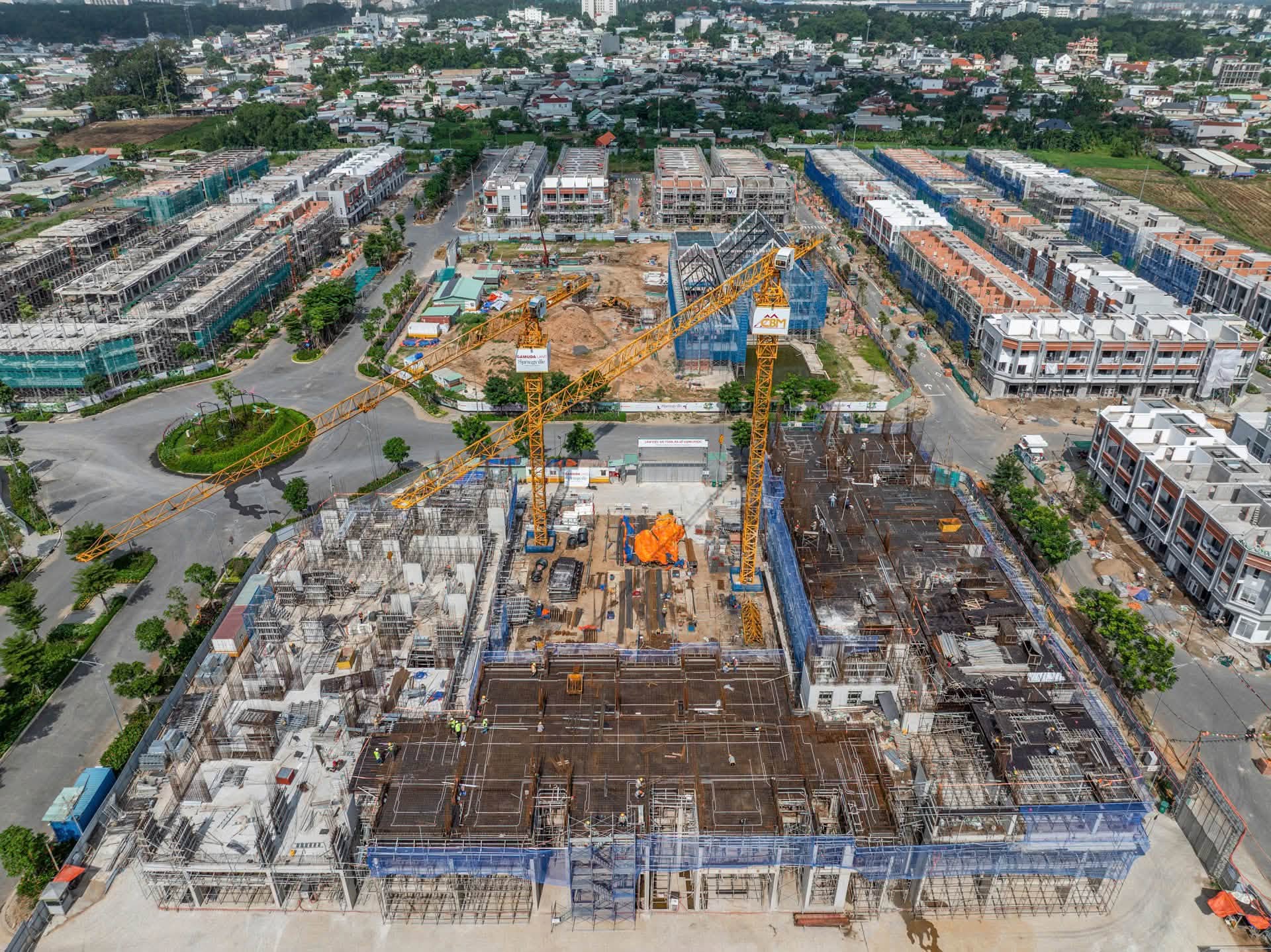 Toàn cảnh công trường Persa Place tại SpringVille tháng 9/2026, nhìn thấy cẩu tháp và khối căn hộ đang thi công.