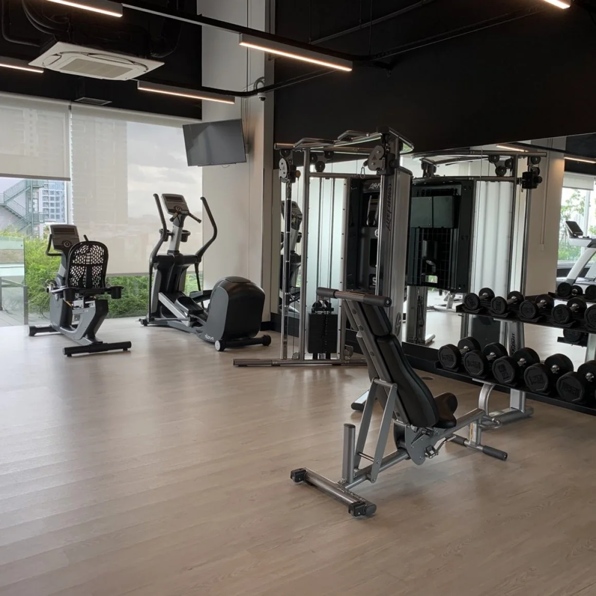 Không gian phòng gym tại Waterina Suites với máy tập và tạ.