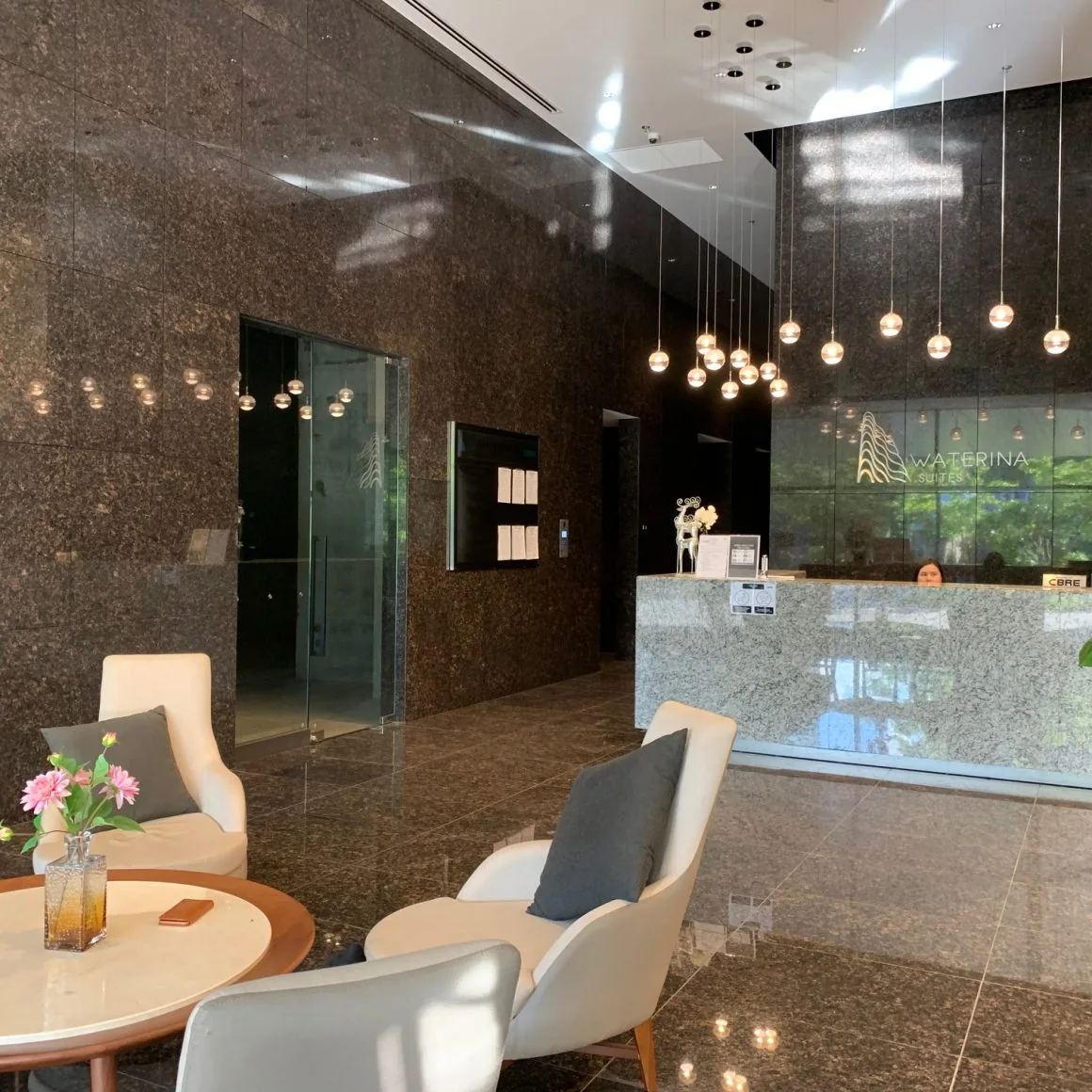 Sảnh đón tiếp Waterina Suites với quầy lễ tân và khu ghế chờ.